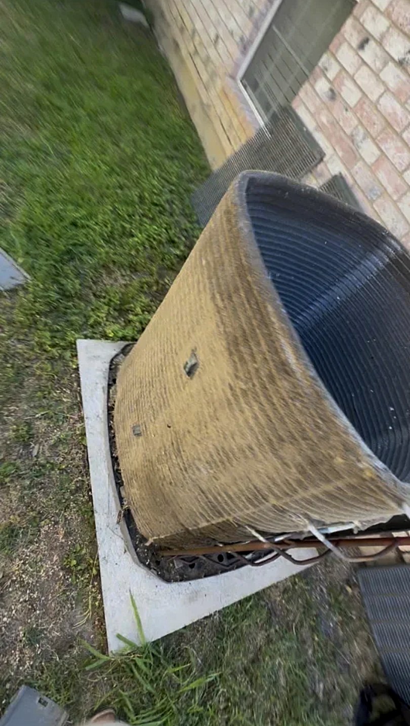 Dirty outdoor condenser coil caked with dirt and debris before cleaning